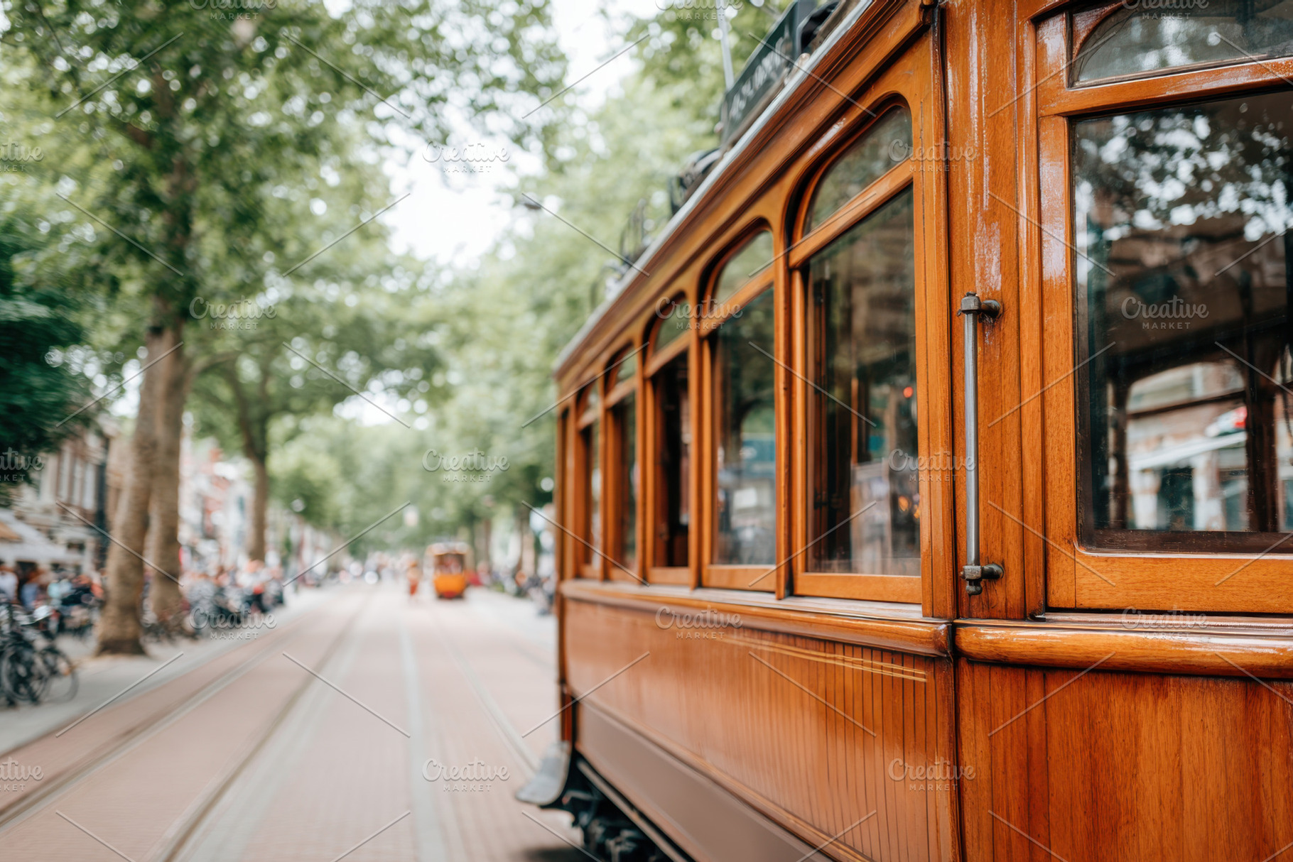 Vintage wooden tram on a tree-lined street, a Transportation Photo by AlyaAnd