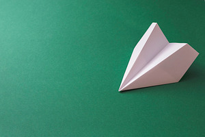 Paper plane on dark green background