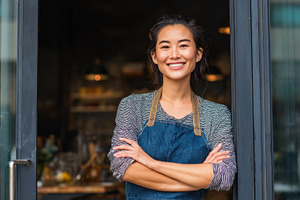 Woman stands at cafe door smiling, a Photo by Beautiful things