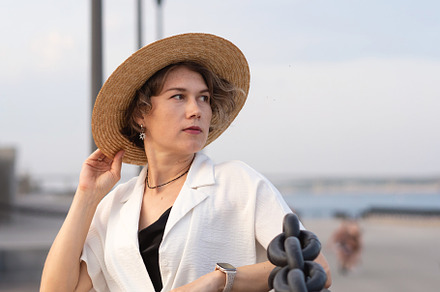 Thoughtful woman in straw hat seated