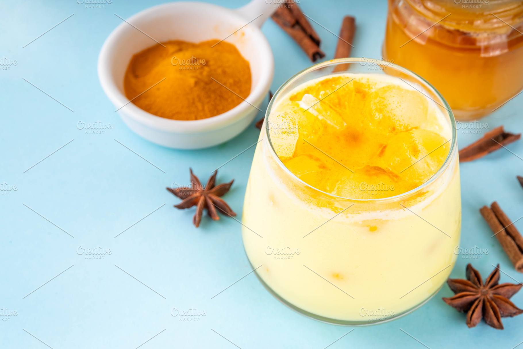 Iced golden milk drink, turmeric latte with ice cubes, a Food & Drink Photo by Rimma