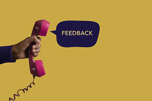 Hand holding retro phone representing customer feedback review,, a Photo by salmon.black