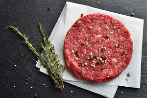 Fresh raw beef burger patty featuring beef, prime, and black angus