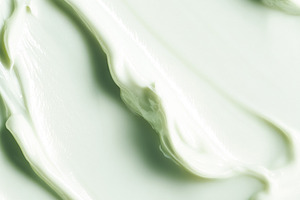 Smooth green skincare cream texture background spreading on a su, a Photo by Studio ANNA