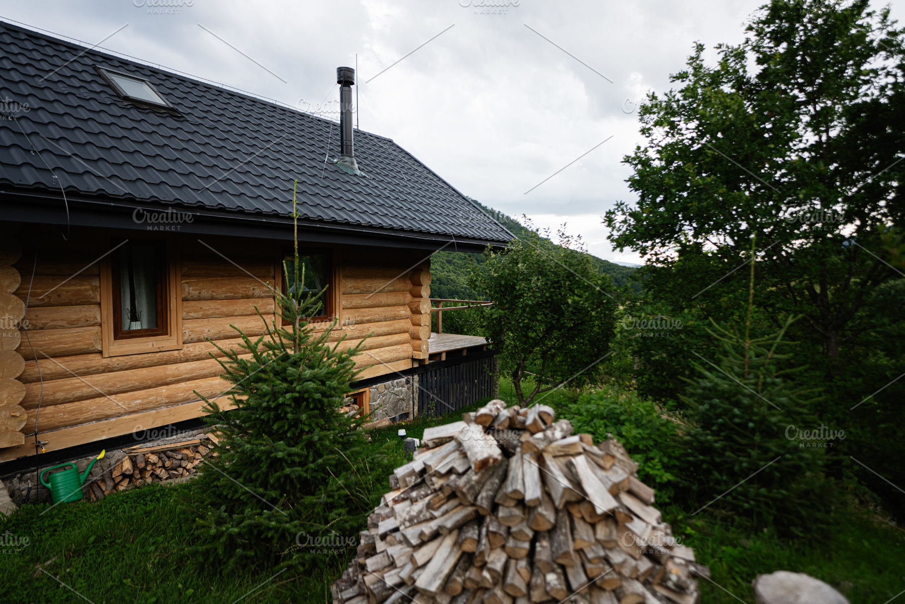 Rustic log cabin surrounded by lush green trees and stacked firewood, a Photo by AS photostudio