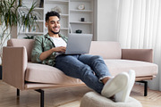 Arab Freelancer Working On Laptop At Home And Listening Music In Earphones, a Photo by Prostock-Studio (Thumbnail 1 of 2)