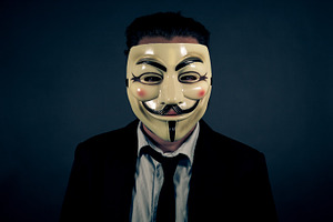 Man in Suit Wearing Anonymous Mask