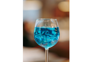 Glass of blue lagoon cocktail on bar, a Food & Drink Photo by Fascinadora