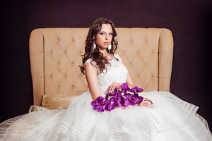 Beautiful bride in luxury hotel room containing bride, model, and white