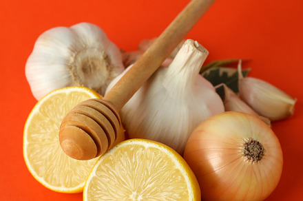 Concept of treatment colds with honey and garlic on orange backg, a Food & Drink Photo by AtlasStudio