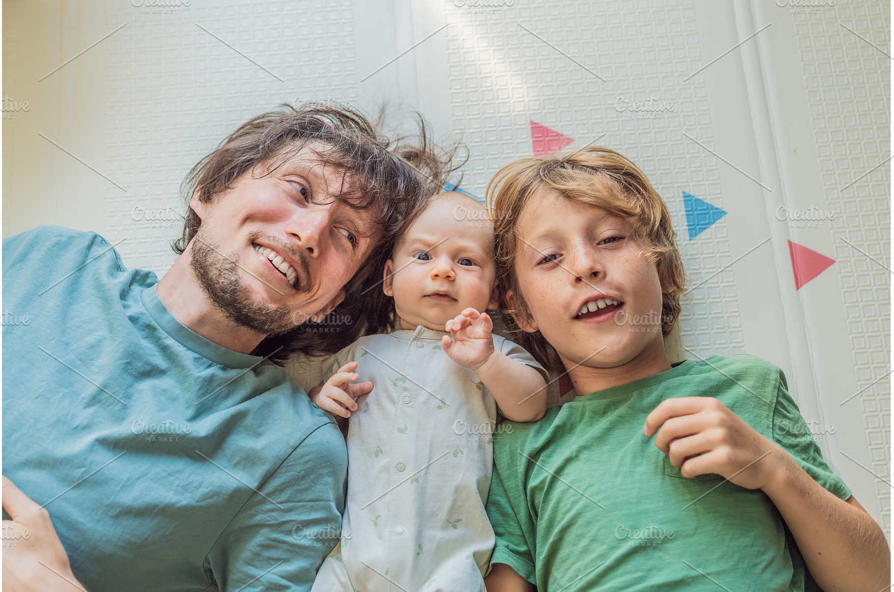 Father, son, and newborn baby lying, a Person Photo by Elizaveta Galitskaya