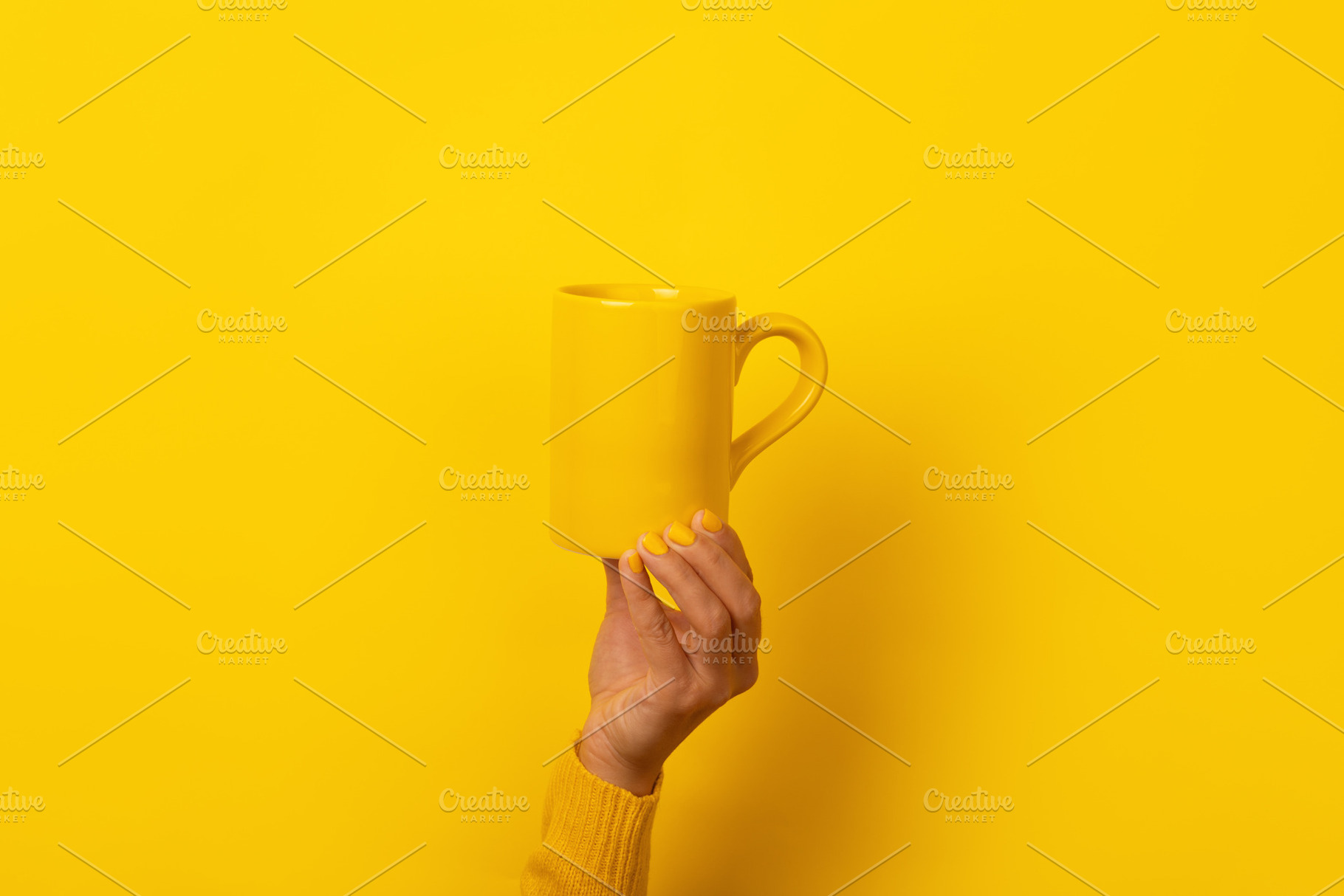 Hand with yellow nails and sweater holding a plain yellow mug ag, a Food & Drink Photo by Ales Munt