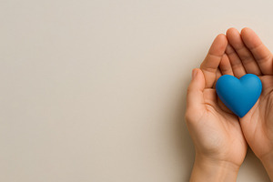 Men health awareness symbol, hands holding blue heart on beige b, a Photo by Dvoevnore photos