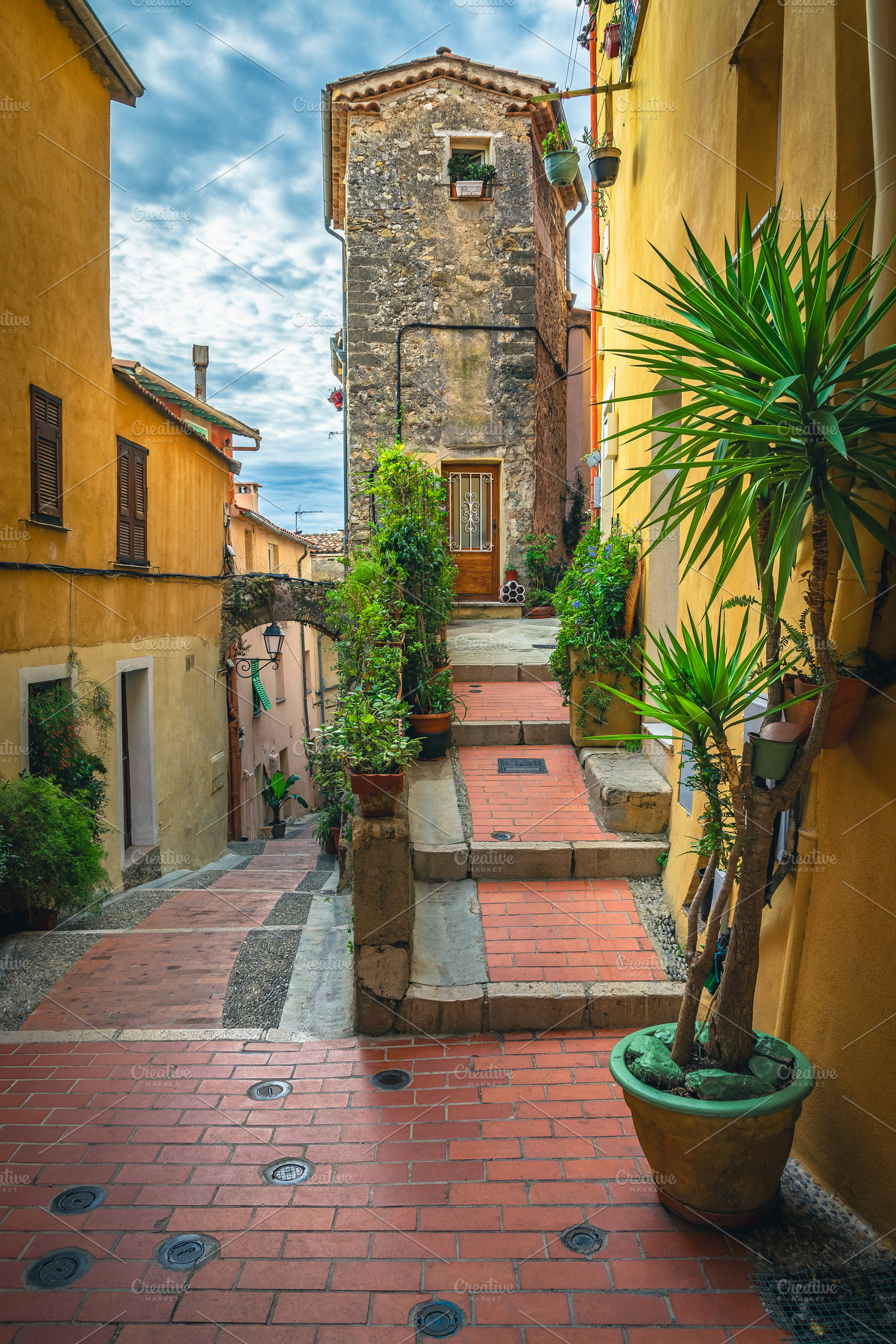 Cozy narrow street in Menton, France, an Architecture Photo by Alpine Dreams