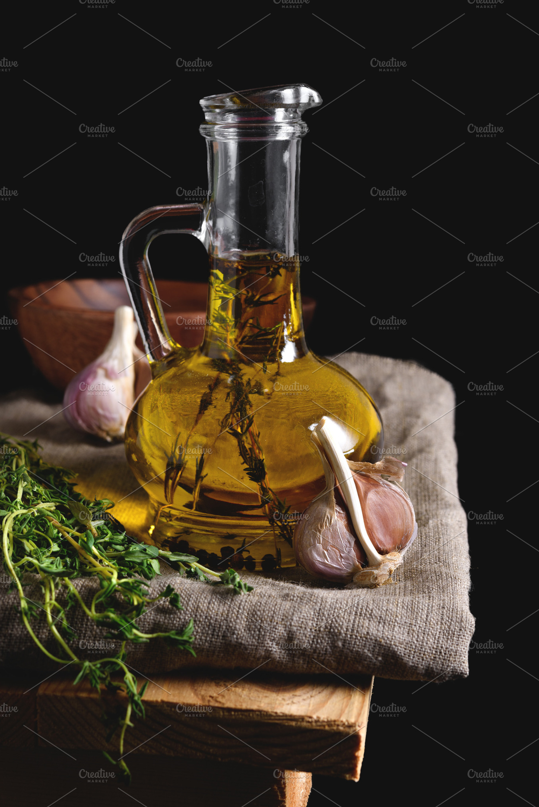 Olive oil in glass bottleon linen napkin on a dark background, a Food & Drink Photo by Edgieus