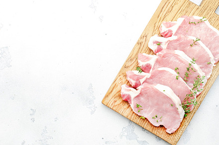 Raw pork chops, meat on cutting board prepared for cooking. Whit, a Food & Drink Photo by 5PH