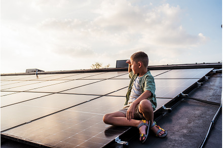 Cute boy sitting on roof with solar