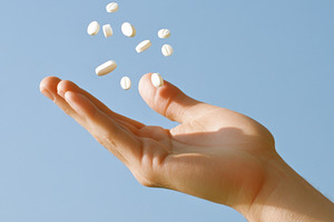 Hand with pills floating in the air, a Photo by Dvoevnore photos