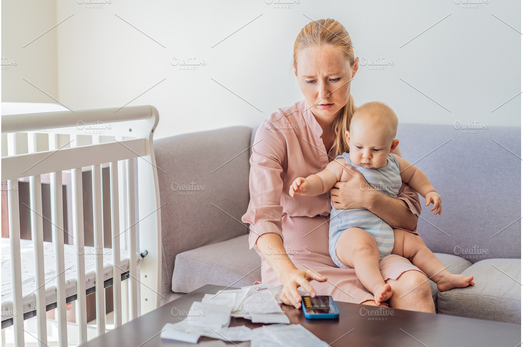 Mother sitting on sofa holding baby, a Person Photo by Elizaveta Galitskaya