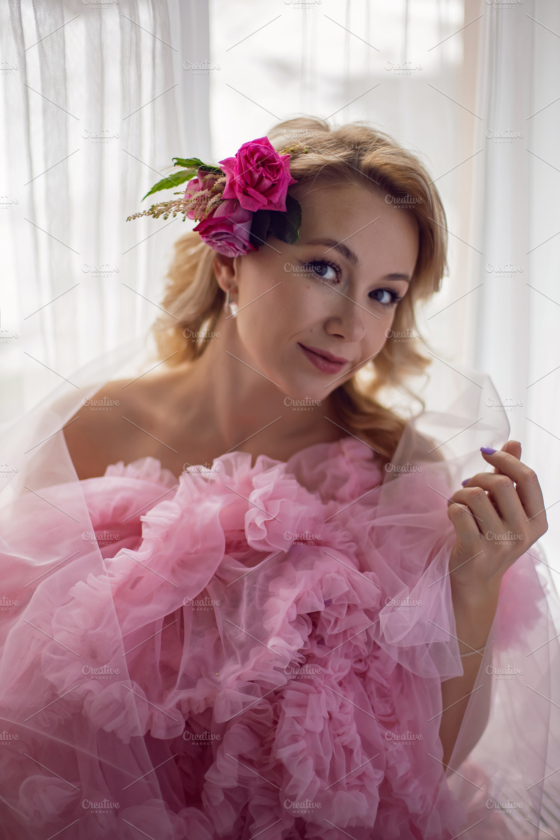 portrait of a fashionable blonde woman in a pink dress and rose flower in her h, a Person Photo by SaulichPhoto