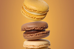 A vertical stack of five multi-colored macarons in chocolate, va, a Food & Drink Photo by ndanko