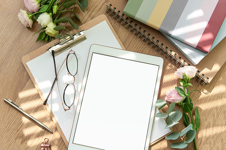Stationery workspace with a blank tablet, notebook, and flowers, a School & Education Photo by Olena Rudo