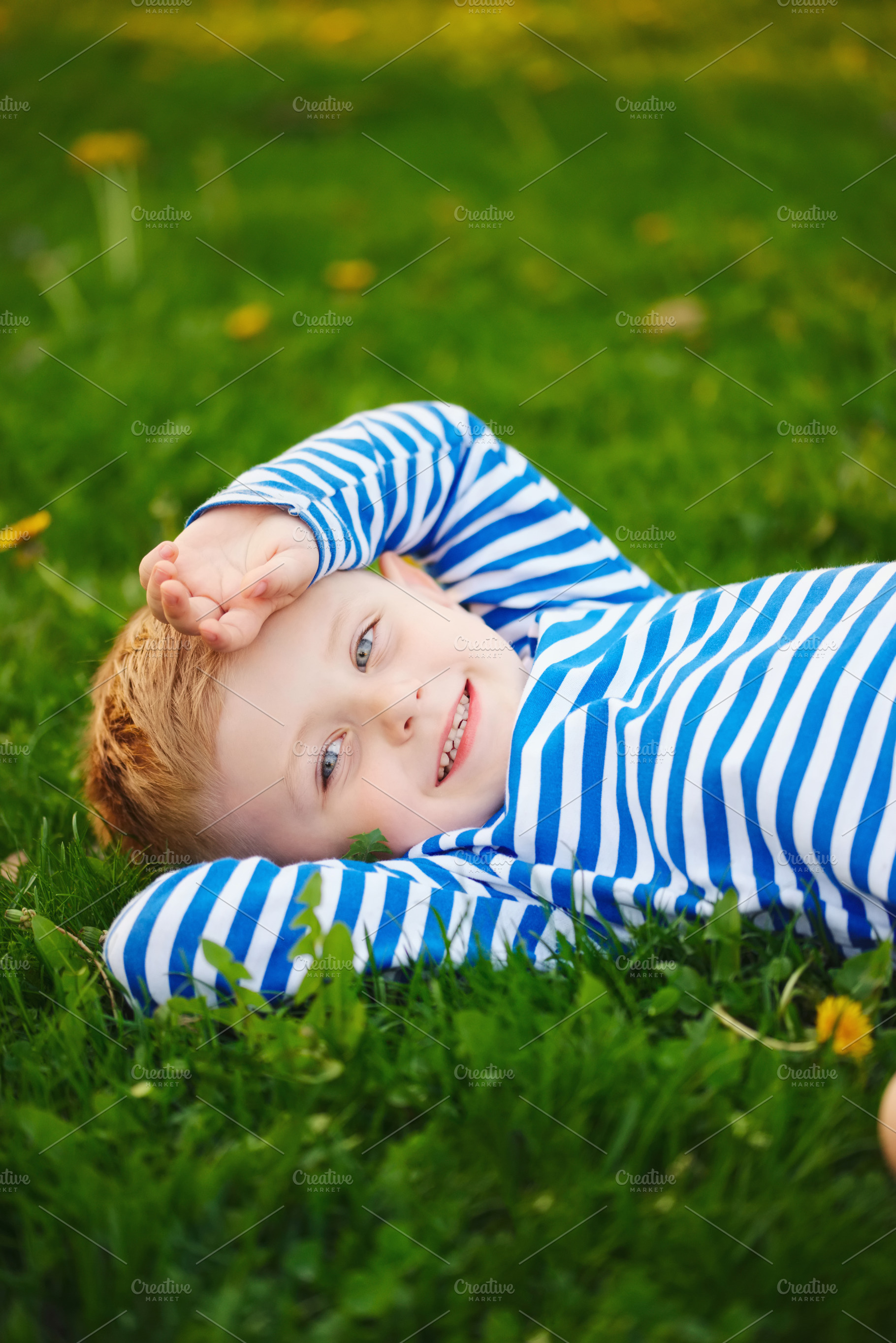 Little boy lying on the grass containing green, grass, and boy, a Nature Photo by AlohaHawaii