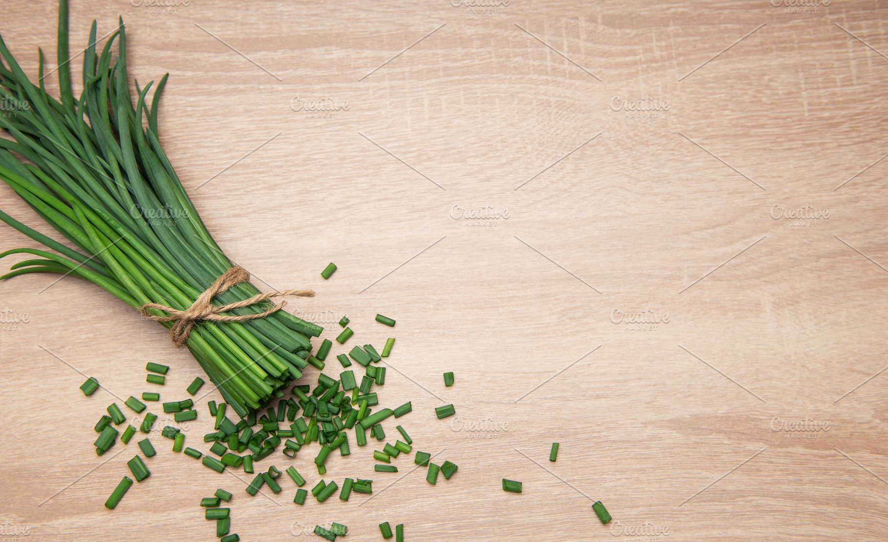 Freshly cut chives tied with twine on wooden table, a Food & Drink Photo by Olena Rudo