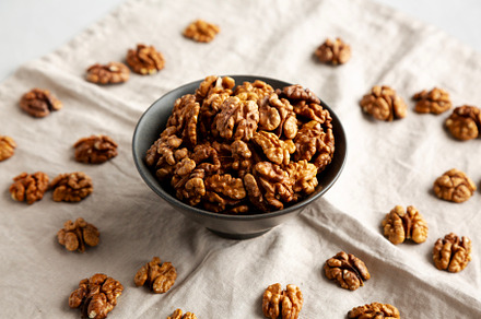 Raw Walnut Halfs in a Bowl, side view.