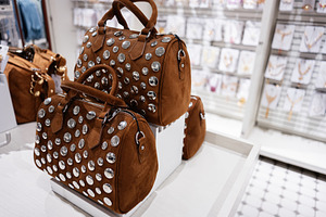 Display of stylish brown studded handbags in fashion store, a Photo by AS photostudio