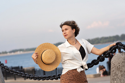 Woman holding straw hat confidently