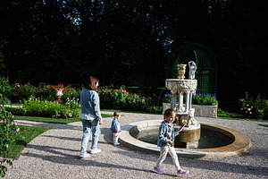 Family enjoying a walk near a fountain in Lancut, Poland garden, a Photo by AS photostudio