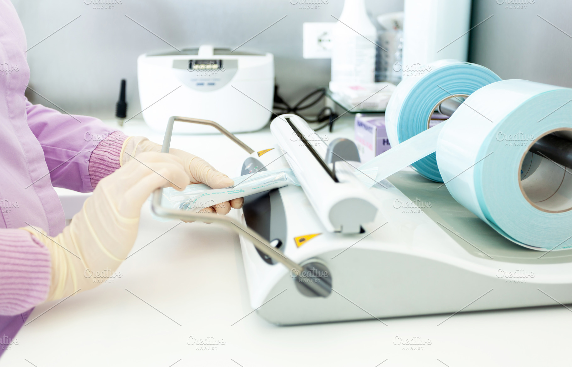 Nurse sealing sterile medical instruments using vacuum packing machine, a Health & Medical Photo by Antonio Gravante Market