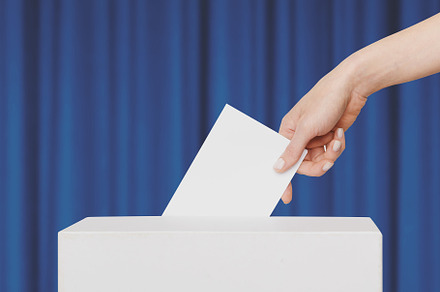 Woman Voter Put Ballot In Voting Box