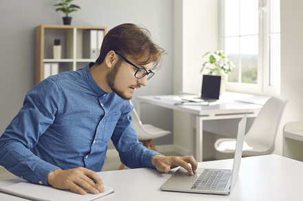 Young man sitting at desk, using, a Technology Photo by StudioRomantic