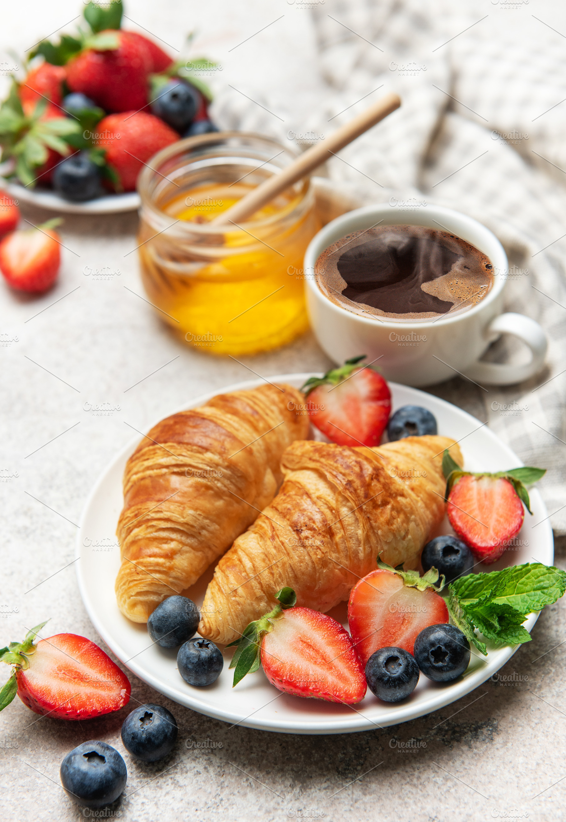 Delicious breakfast with croissants, coffee, berries and honey e, a Food & Drink Photo by Olena Rudo