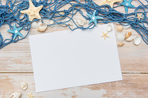 Fishing net, seashells and starfishes framing blank paper on woo, a Holiday Photo by Olena Rudo