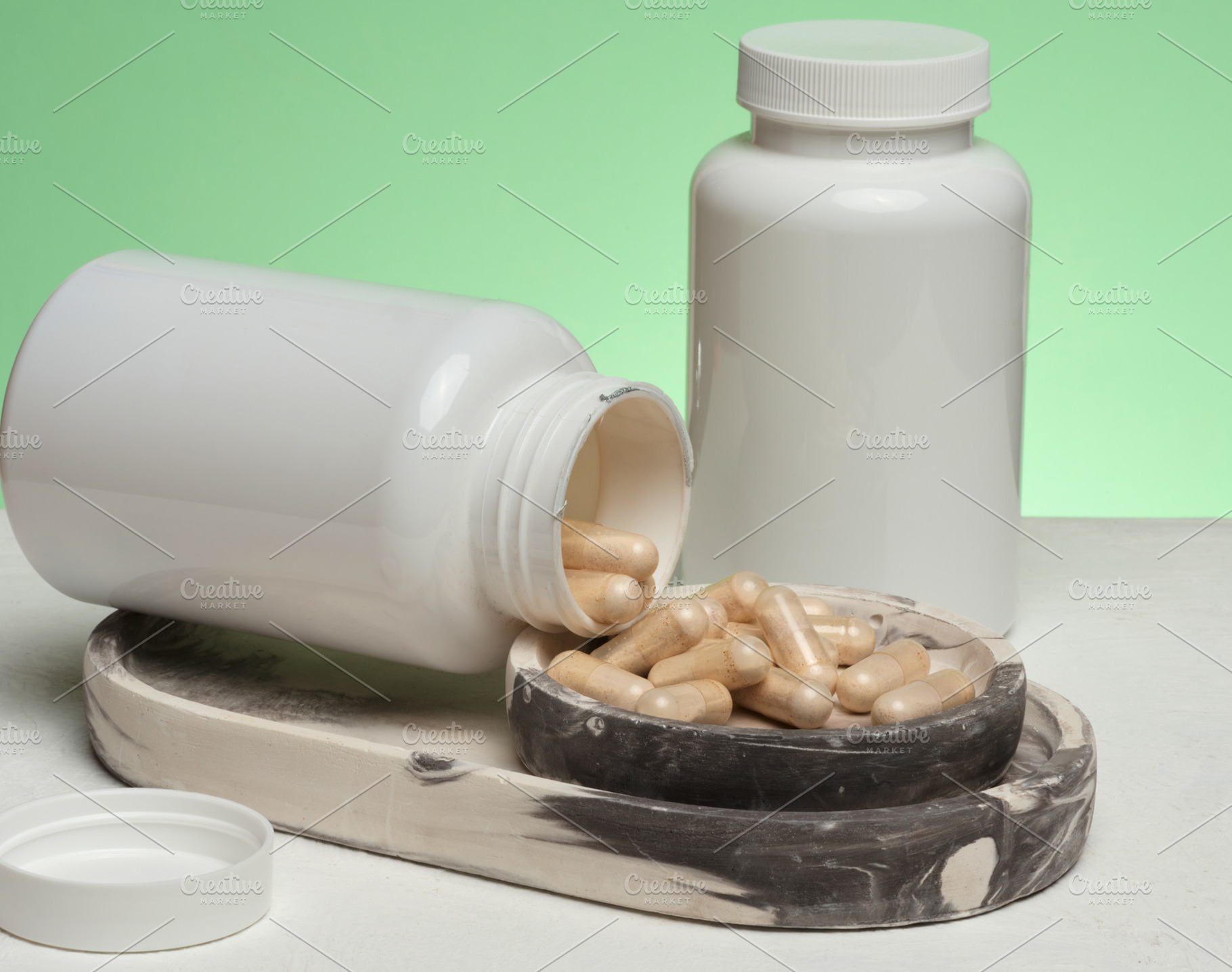 Two white plastic jars, one of which is overturned and capsules, a Health & Medical Photo by ndanko