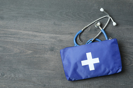 First aid medical kit on dark wooden background, a Health & Medical Photo by AtlasStudio