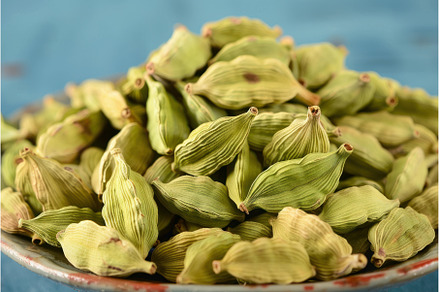Green cardamom pods filling a bowl, a Food & Drink Photo by Ylivdesign