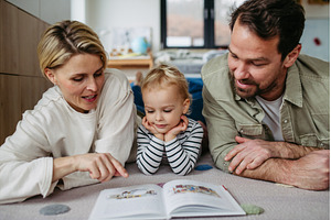 Parents reading book with little son, a Person Photo by HalfPoint