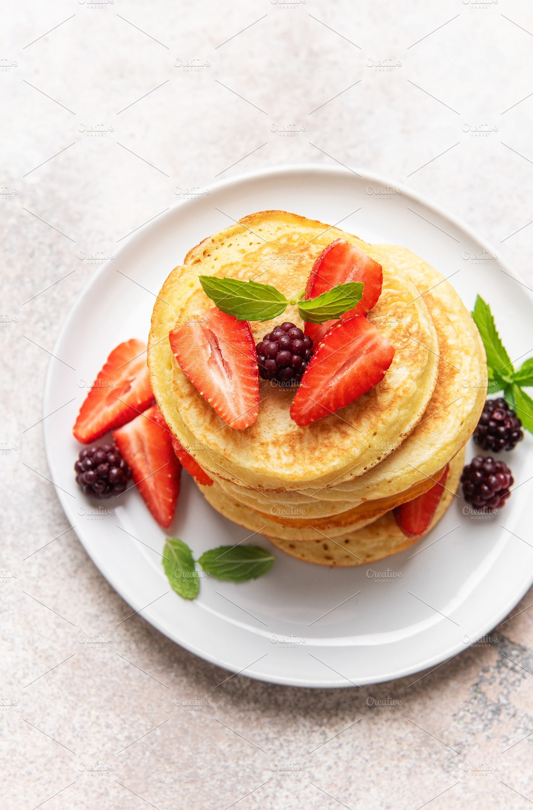 Stack of pancakes with fresh strawberries and blackberries, a Food & Drink Photo by Olena Rudo