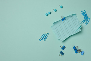 Blue stationery supplies a stack of sheets, paper clips, and pus, a Business Photo by ndanko