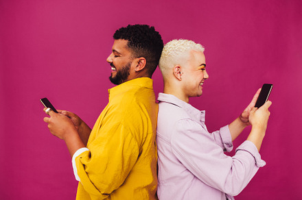 Carefree gay couple using their mobile phones in a studio, a Person Photo by Jacob Lund