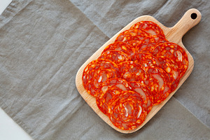 Cold Meat Chorizo Slices on a Wooden Board, top view. Copy space, a Food & Drink Photo by LiudmylaChuhunova