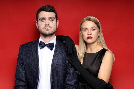 Concept of Halloween, young man and woman on red background, a Person Photo by AtlasStudio PRO