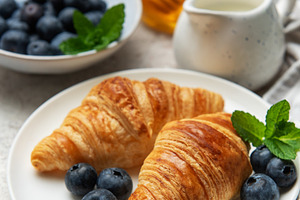 Delicious french croissants with fresh blueberries and honey for, a Food & Drink Photo by Olena Rudo
