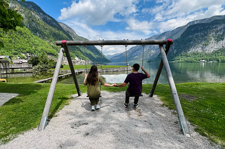Couple enjoying a serene moment on a lakeside swing in Hallstatt, Austria., a Photo by AS photostudio