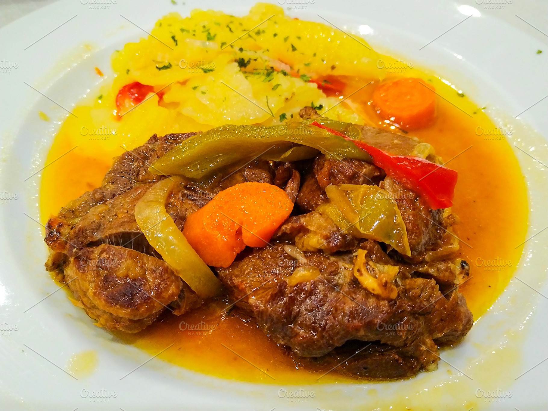 Braised meat with vegetables and potatoes on white plate, a Food & Drink Photo by DanFLCreativo