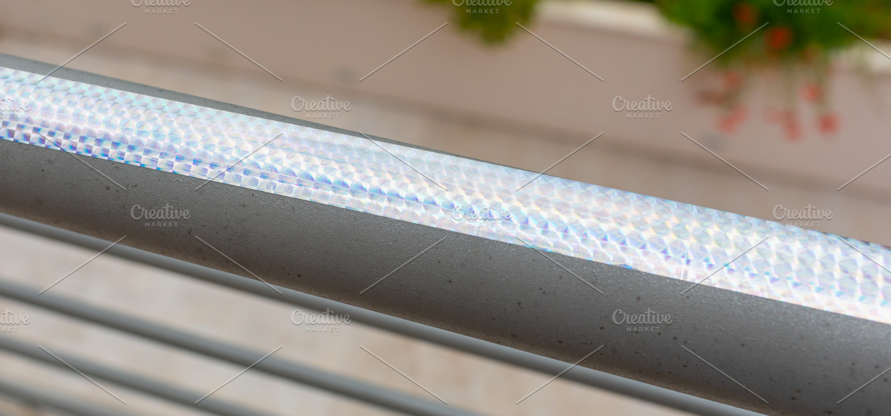 Iridescent holographic bird repellent tape reflecting sunlight on a railing, an Abstract Photo by Antonio Gravante Market